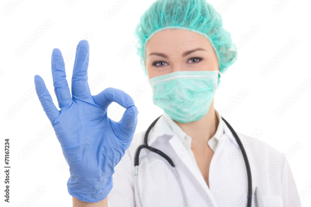 young woman doctor in surgeon mask, cap and rubber gloves showin young woman doctor in surgeon mask, cap and rubber gloves showin