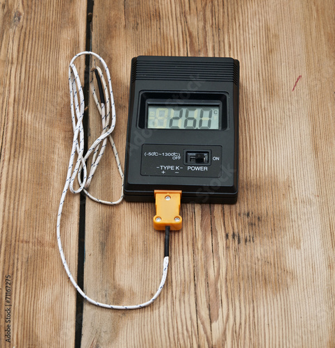Digital thermometer on wooden table top