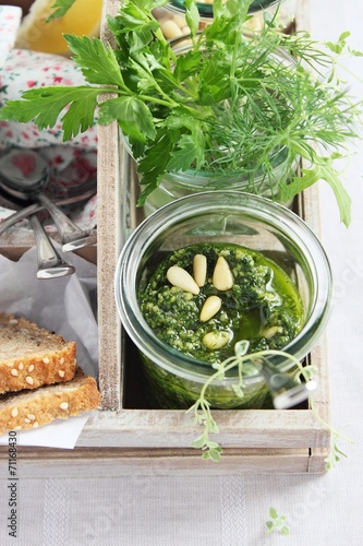 Fresh delicious homemade green herbs pesto in glass jar