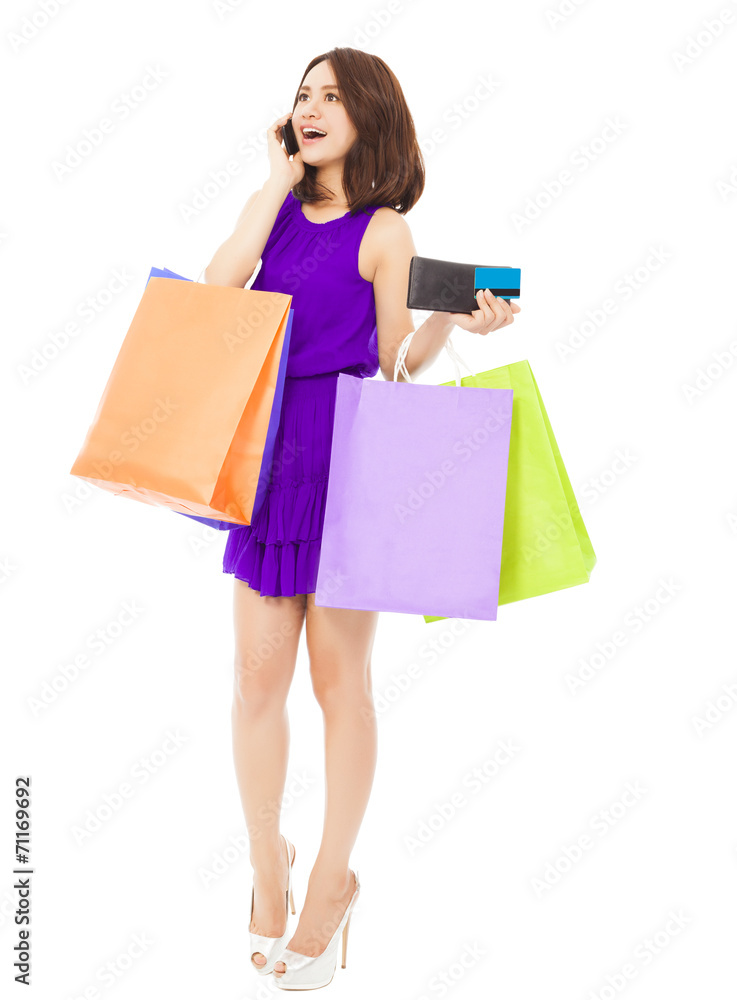 beautiful woman with shopping bags talking on phone