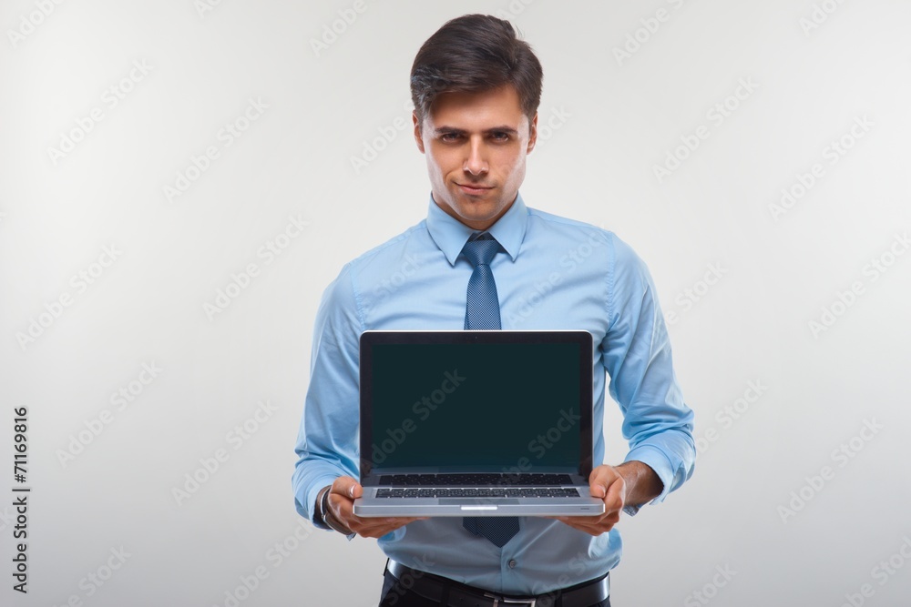Business man holding a laptop against a white background Business man holding a laptop against a white background