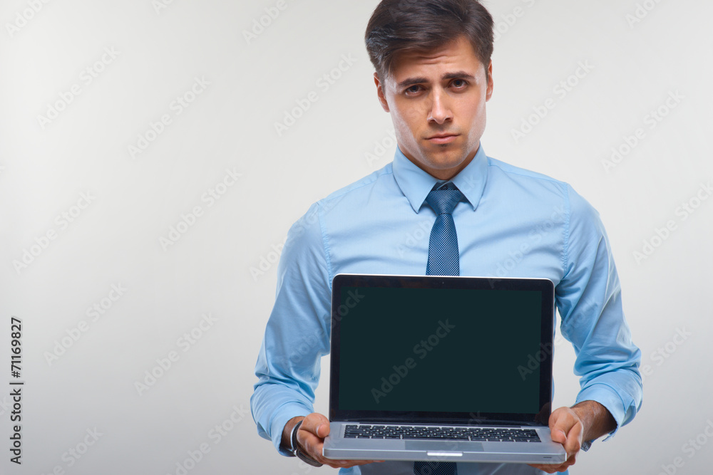 Business man holding a laptop against a white background Business man holding a laptop against a white background