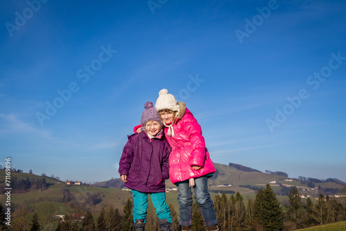 Two girls standing on a rock