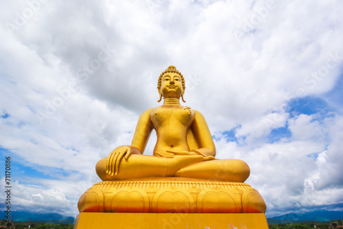 Obraz na plátně Large golden buddha statue on blue sky background