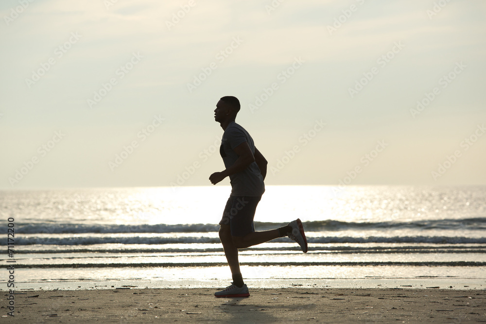Fototapeta premium Healthy young man jogging on beach