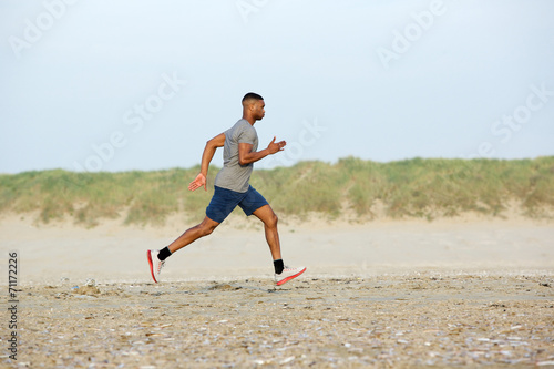 Male runner exercising on the beach