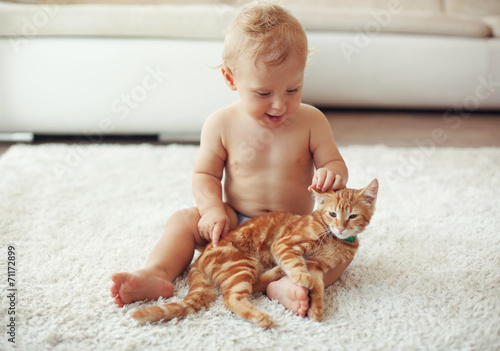 Toddler playing with cat