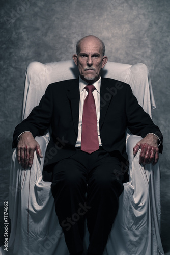 Corrupt businessman with bloody hands sitting in white chair. Gr