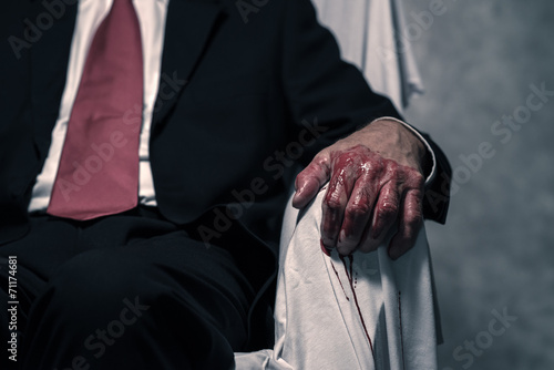 Bilde på lerret Bloody hand of businessman sitting in white chair.