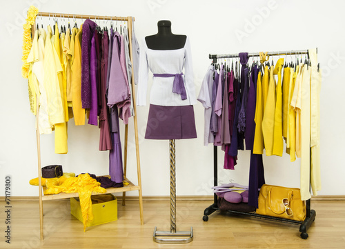 Wardrobe with complementary colors violet and yellow clothes.
