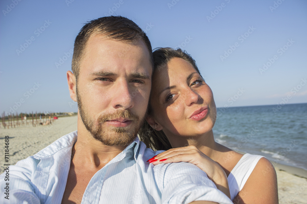 Happy couple taking a photo on a beach Happy couple taking a photo on a beach