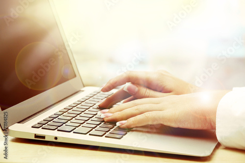 Female hands on laptop, close-up