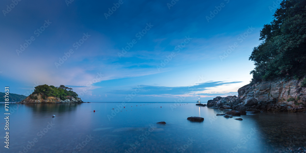 small island at sunrise with stoney coast at elba italy