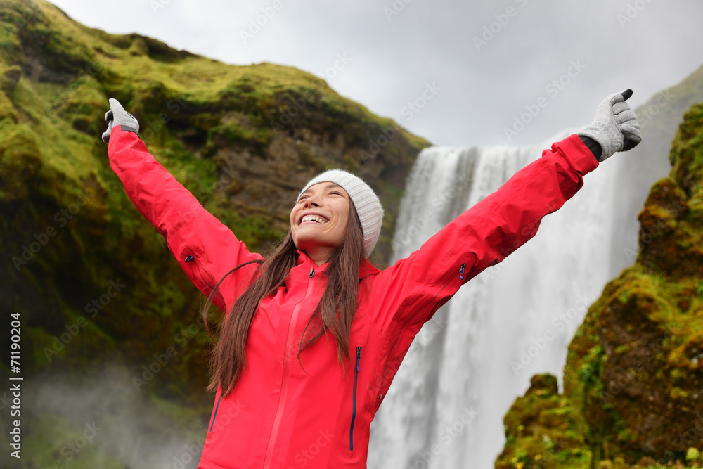 Naklejka premium Happy woman by waterfall Skogafoss on Iceland