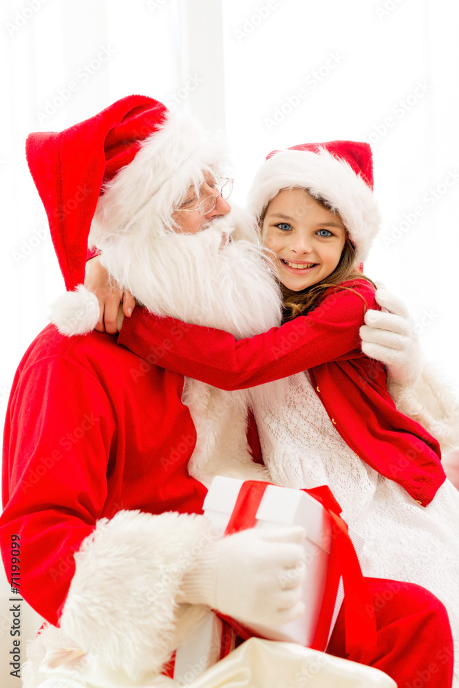 smiling girl with santa claus and gift at home smiling girl with santa claus and gift at home