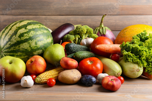 Fresh organic fruits and vegetables on wooden background