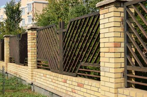 An attractive metal fence with brick posts