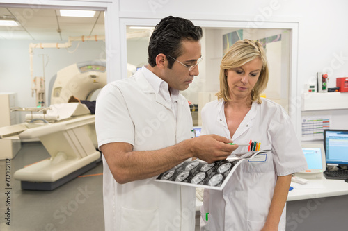 Doctors examining MRI scan report in medical scan room