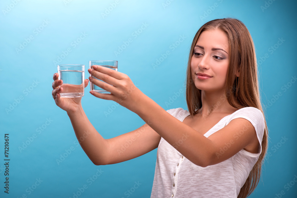 Portrait of a pretty girl holding two glasses with clean water i Portrait of a pretty girl holding two glasses with clean water i