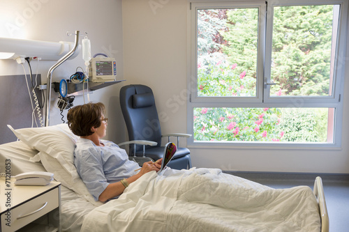Woman looking through a window on hospital bed