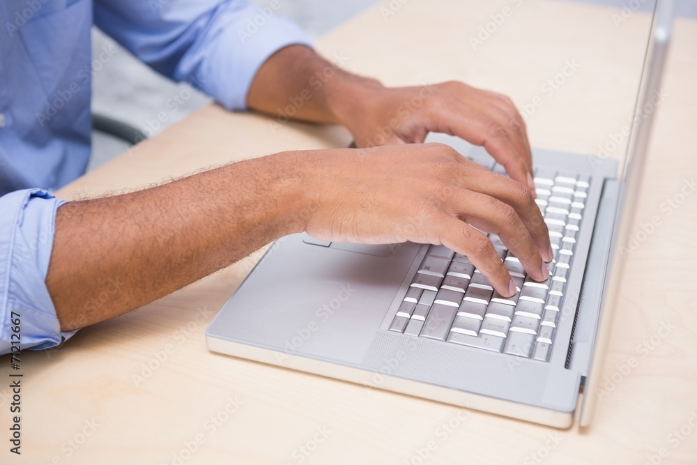 Mid section of businessman using laptop at desk Mid section of businessman using laptop at desk
