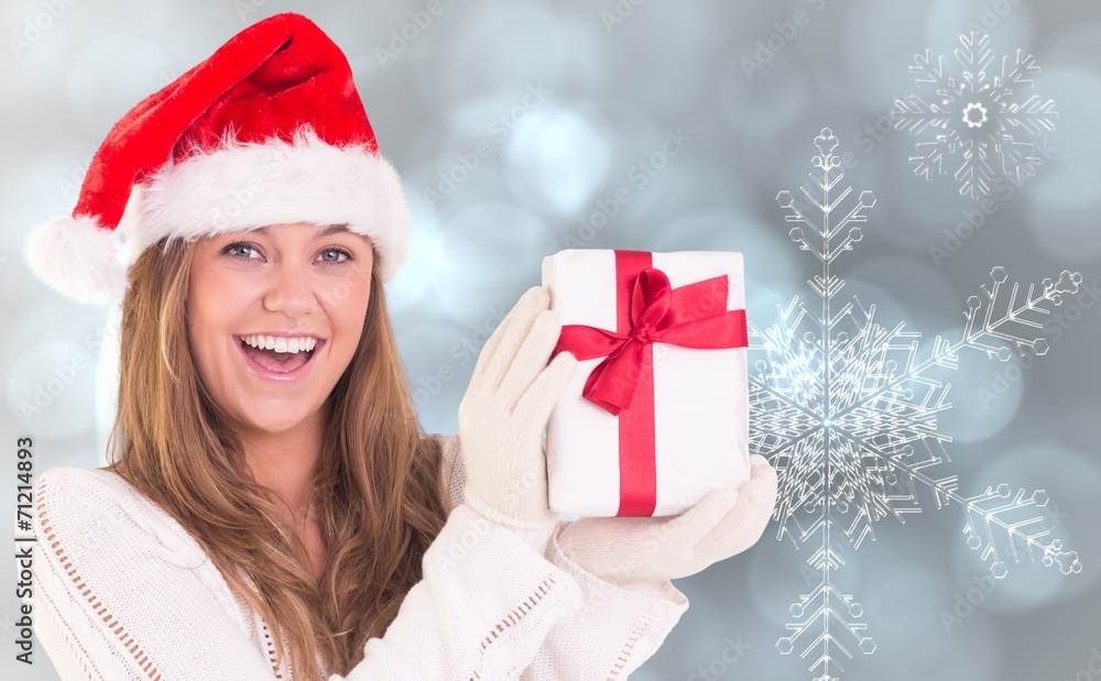Composite image of festive blonde holding a gift Composite image of festive blonde holding a gift