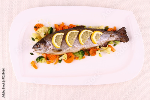 Grilled whole trout with vegetables and lemon