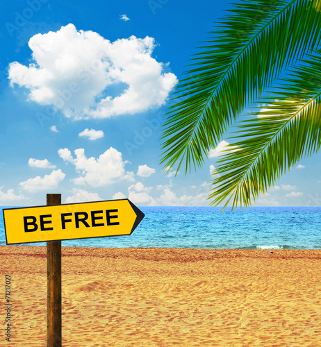 Tropical beach and direction board saying BE FREE