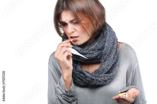 woman taking her temperature wile feeling sick and with fever photo