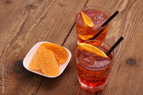 Spritz aperitif - two orange cocktail, ice cubes, potato chips photo