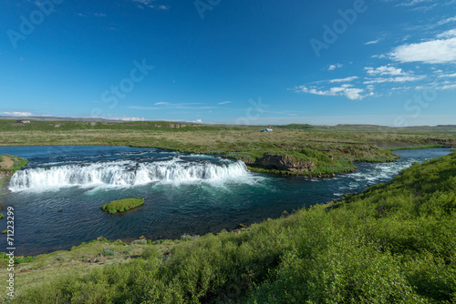 Scenic view of Islandic landscape with river and waterfall.