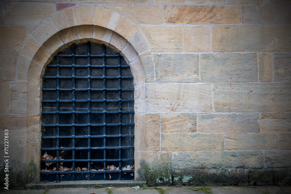 Hintergrund gelbe Sandsteinmauer mit vergittertem Fenster Stock Photo
