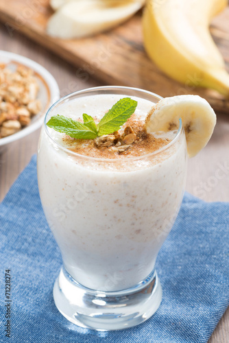 milkshake with banana, granola and cinnamon in a glass