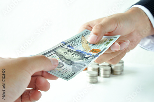 Hand giving money United States dollar (USD) bill