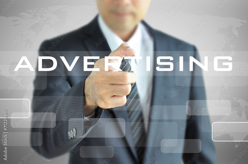 Businessman pointing to ADVERTISING word on virtual screen Businessman pointing to ADVERTISING word on virtual screen