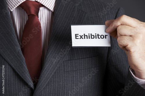 Businessman Attaching Exhibitor Badge To Jacket photo