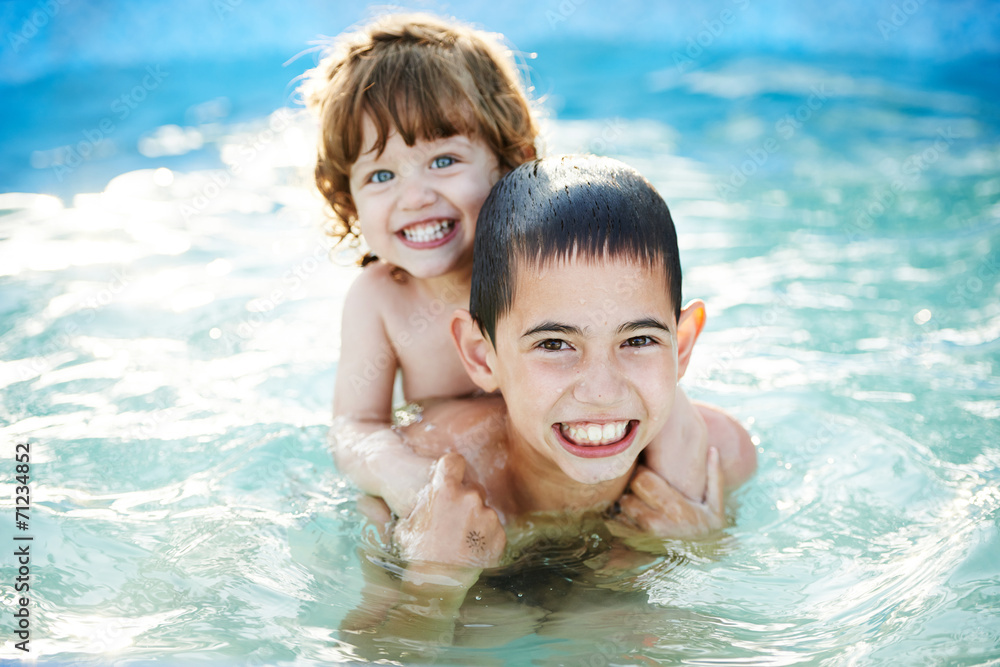 brother and sister bathe outside in pool