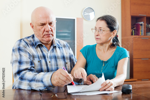 serious mature couple fills in questionnaire