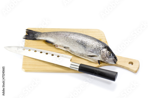 raw fish on a cutting board and knife