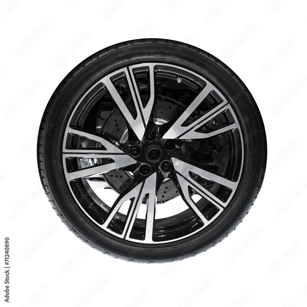 Photo of new automotive wheel on black disc isolated on white ba Photo of new automotive wheel on black disc isolated on white ba