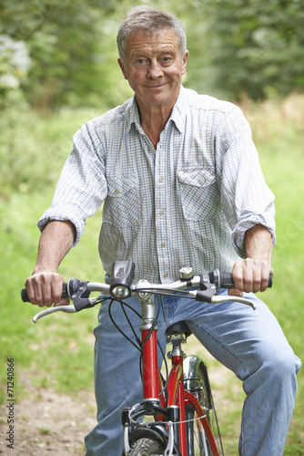 Senior Man Enjoying Cycle Ride In The Countryside