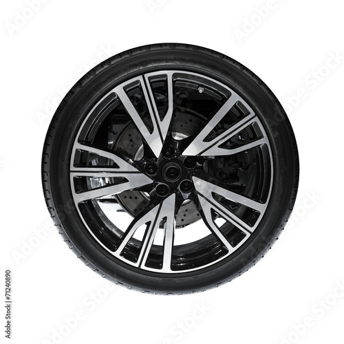 Photo of new automotive wheel on black disc isolated on white ba