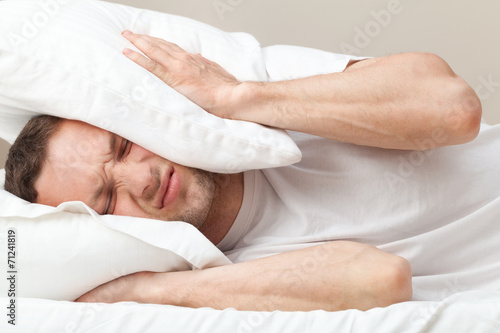 Portrait of dissatisfied Young Caucasian man in bed