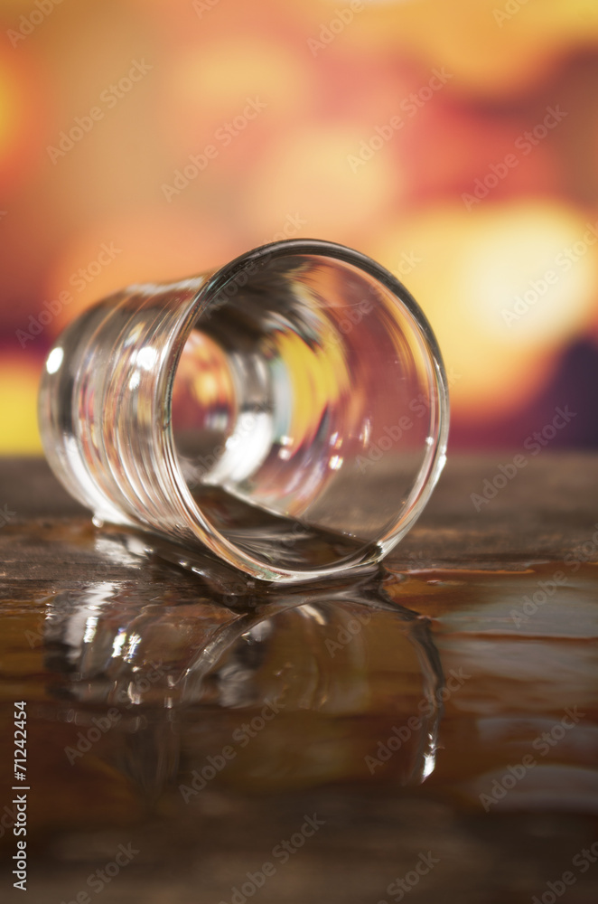 glass of rum whiskey over defocused lights background glass of rum whiskey over defocused lights background