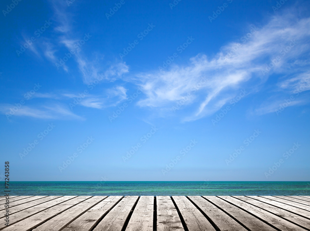 Empty gray wooden pier with sea and cloudy sky on background
