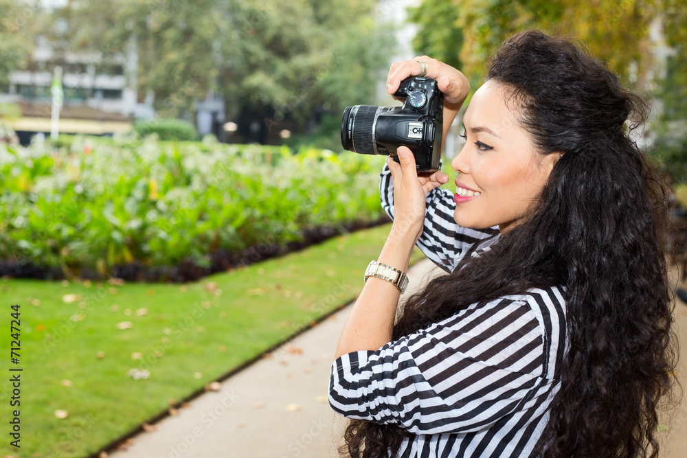 young woman taking photos in the park