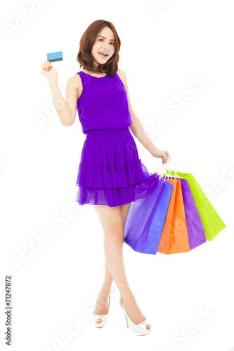 beautiful young woman holding a card and shopping bags. © Tom Wang