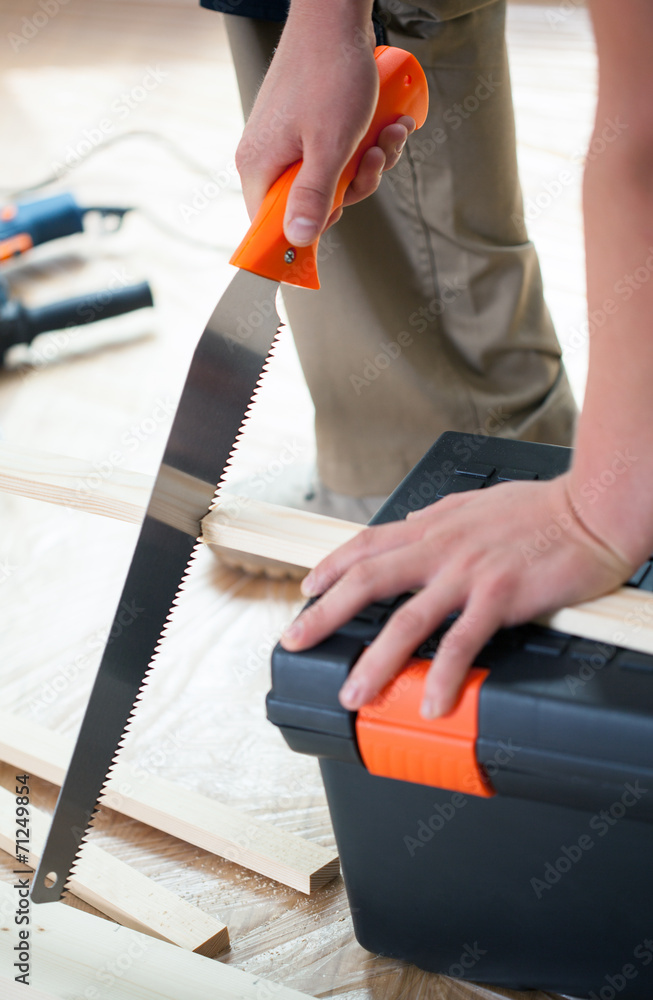 Cutting wooden plank with hand saw Cutting wooden plank with hand saw