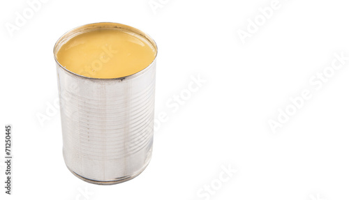 Condensed milk in tin can over white background 