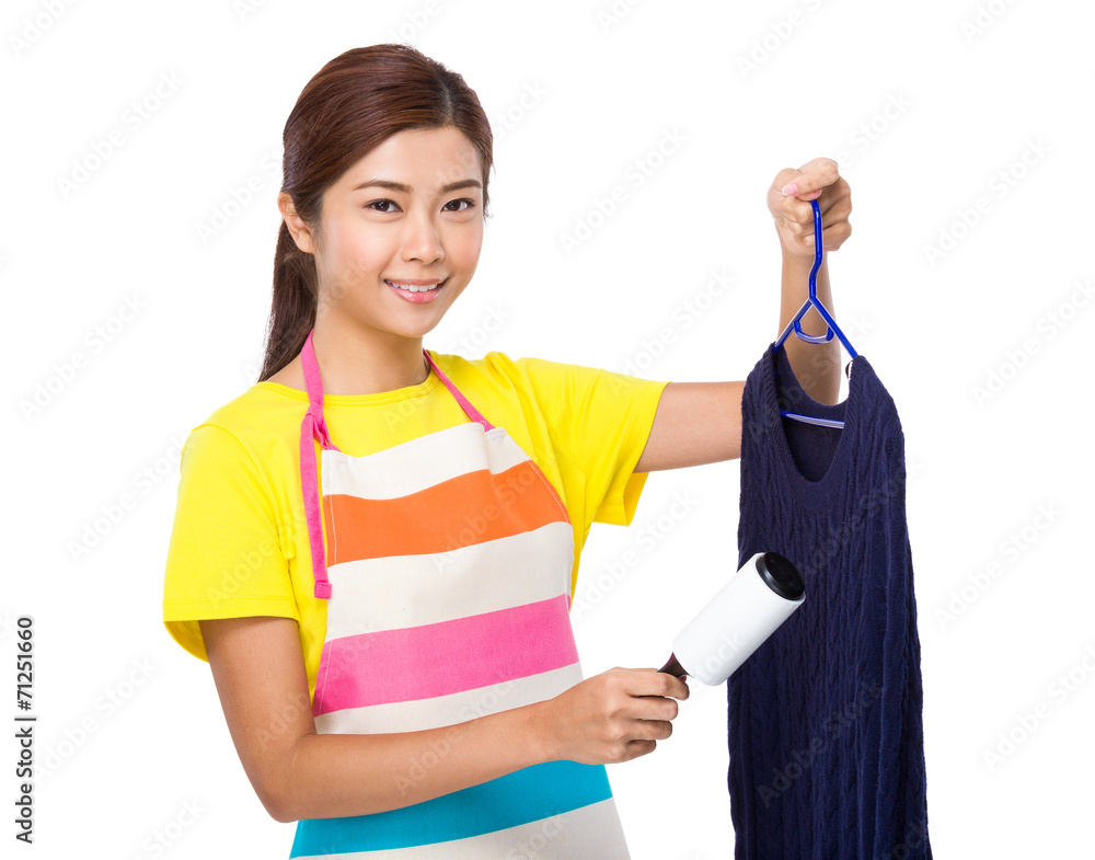 Asian housewife use dust remover on knitwear Asian housewife use dust remover on knitwear